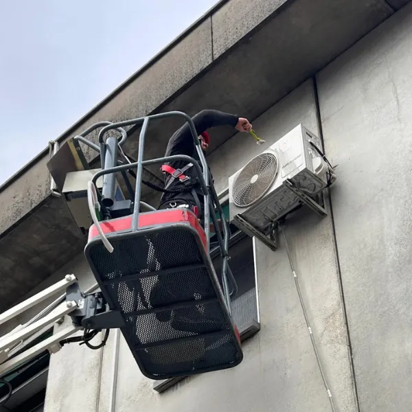 Tecnico su piattaforma aerea per manutenzione climatizzatore