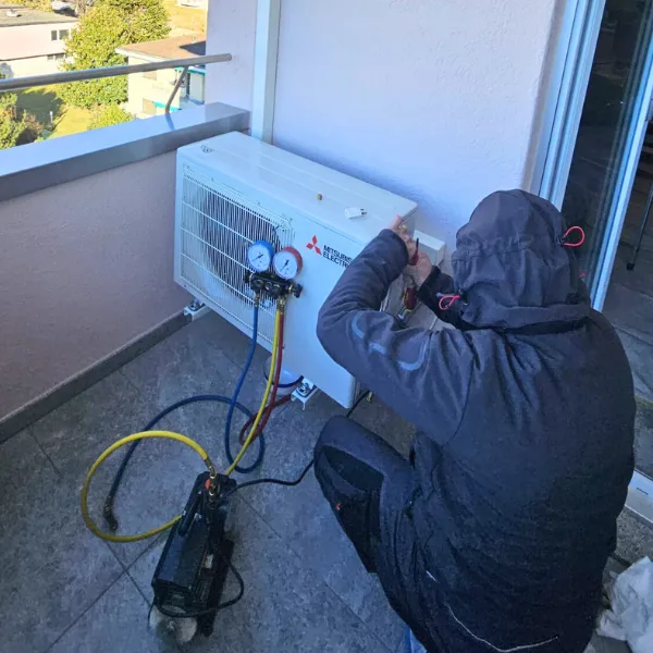 Tecnico ripara climatizzatore su balcone